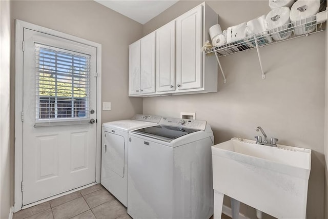 laundry area featuring cabinet space, light tile patterned flooring, a sink, and washing machine and clothes dryer