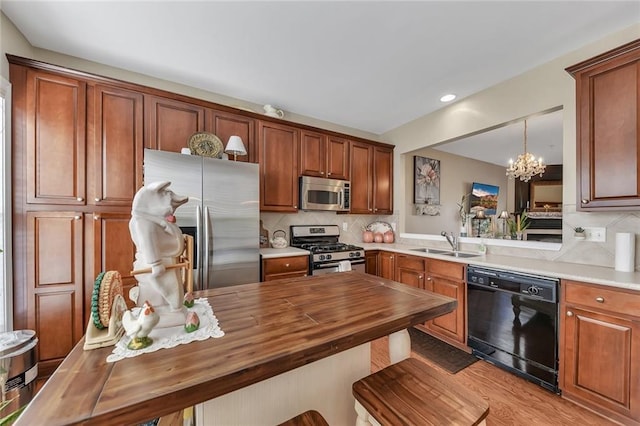 kitchen with stainless steel appliances, decorative backsplash, an inviting chandelier, a sink, and butcher block countertops