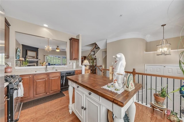 kitchen featuring a sink, wooden counters, stainless steel range with gas cooktop, decorative backsplash, and dishwasher