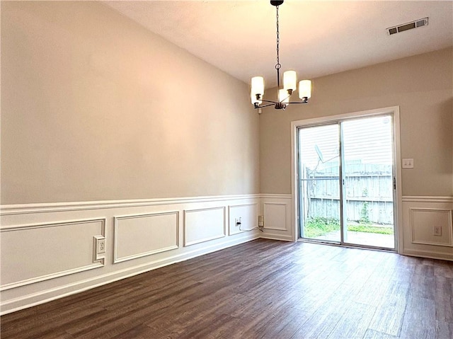 3884 Grovemont Pl, Duluth, GA 30096 - unfurnished dining area with a chandelier, a decorative wall, dark wood-type flooring, and wainscoting