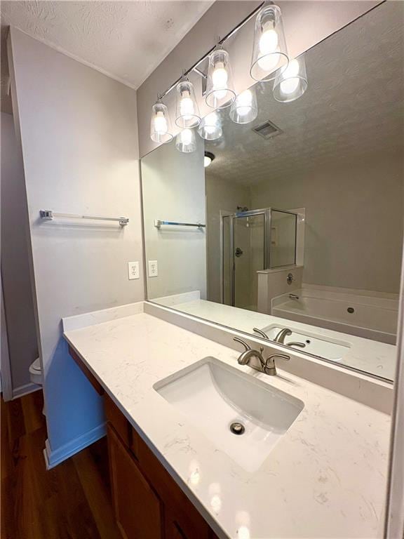 3884 Grovemont Pl, Duluth, GA 30096 - full bath featuring wood finished floors, a shower stall, vanity, a textured ceiling, and a garden tub