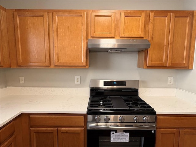 3884 Grovemont Pl, Duluth, GA 30096 - kitchen with stainless steel gas range, under cabinet range hood, and brown cabinetry