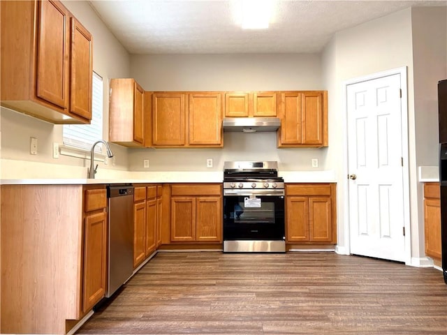 3884 Grovemont Pl, Duluth, GA 30096 - kitchen featuring appliances with stainless steel finishes, under cabinet range hood, dark wood finished floors, and light countertops
