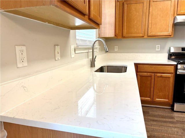 3884 Grovemont Pl, Duluth, GA 30096 - kitchen featuring stainless steel gas range, under cabinet range hood, brown cabinetry, and dark wood-style floors