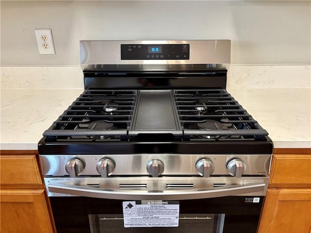 3884 Grovemont Pl, Duluth, GA 30096 - kitchen view of stainless steel gas range oven and brown cabinetry