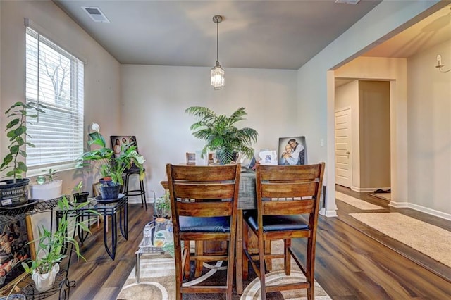 dining space with dark hardwood / wood-style flooring