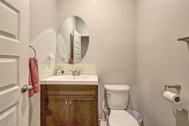 bathroom with vanity, backsplash, and toilet