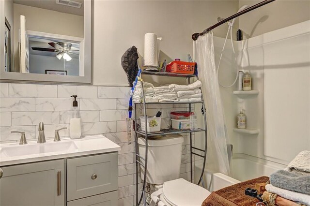 full bathroom featuring ceiling fan, shower / bath combo, tasteful backsplash, toilet, and vanity