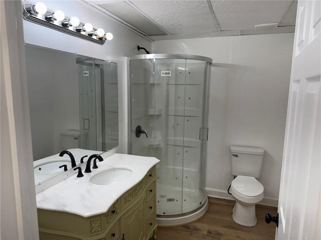 full bath with toilet, a shower stall, wood finished floors, and vanity