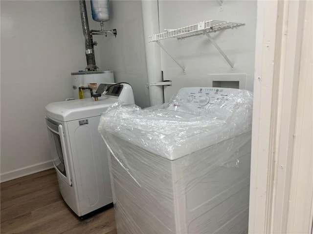 clothes washing area with water heater, wood finished floors, laundry area, independent washer and dryer, and baseboards