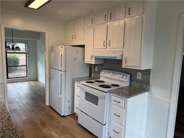 kitchen featuring a notable chandelier, under cabinet range hood, white appliances, wood finished floors, and backsplash