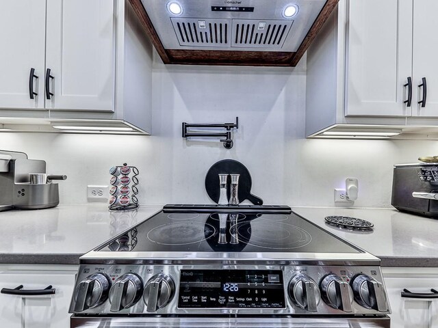 1170 Upper Sweetwater Trl SE, White, GA 30184 - kitchen with white cabinetry, range hood, dark stone counters, and stainless steel electric range oven