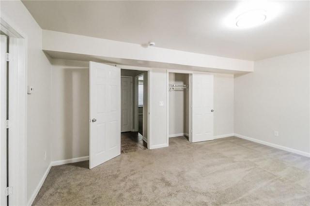 unfurnished bedroom featuring baseboards, carpet, and a closet