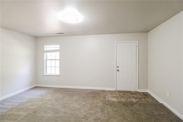 carpeted spare room with visible vents and baseboards