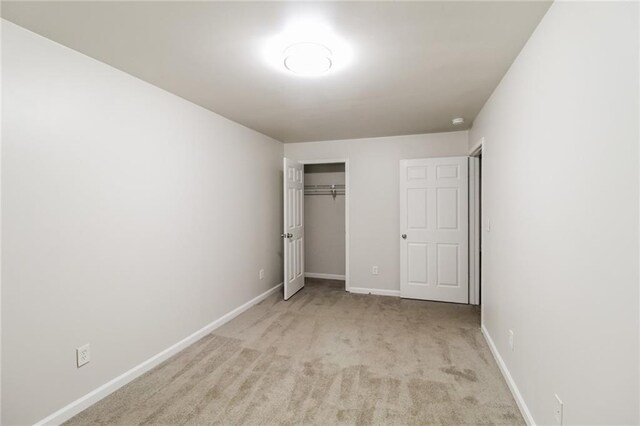 unfurnished bedroom with a closet and light carpet