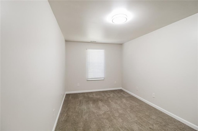carpeted spare room featuring baseboards