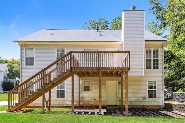 back of property with stairway, a deck, and a chimney