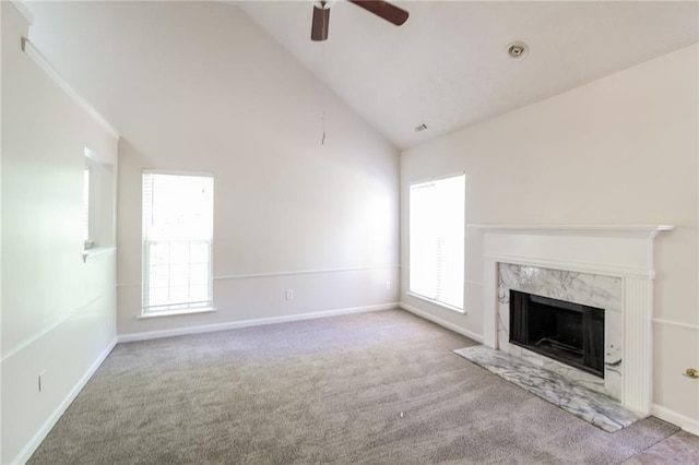 unfurnished living room featuring baseboards, ceiling fan, high vaulted ceiling, a high end fireplace, and carpet flooring
