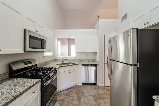 kitchen with stainless steel appliances, white cabinetry, and a sink