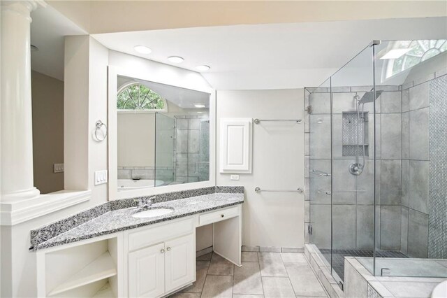 bathroom featuring decorative columns, tile patterned flooring, an enclosed shower, and vanity