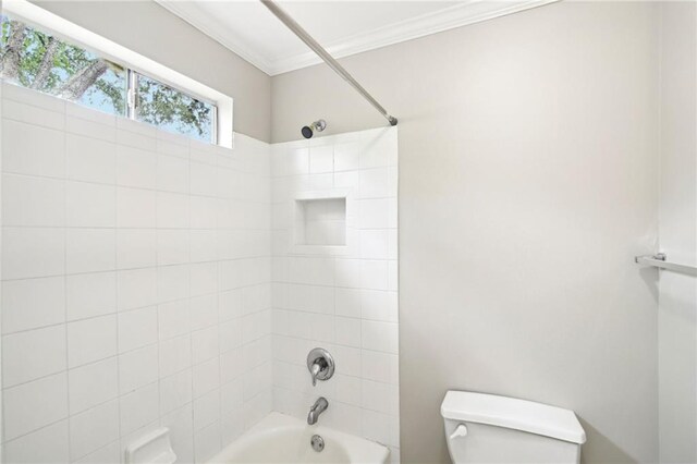 bathroom with toilet, tiled shower / bath combo, and crown molding