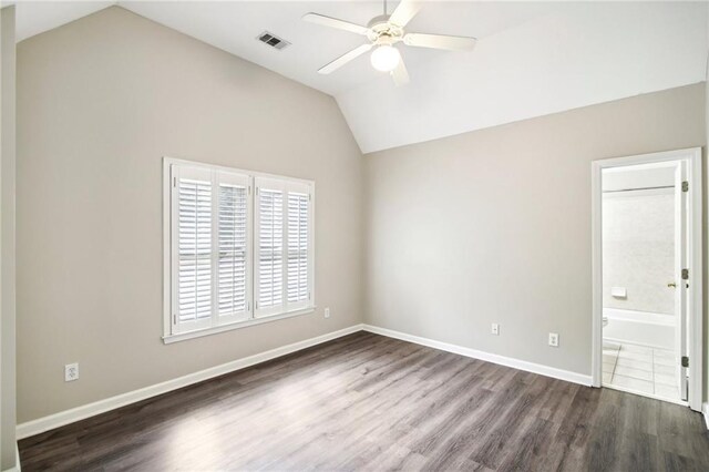 spare room with ceiling fan, vaulted ceiling, and dark wood-type flooring