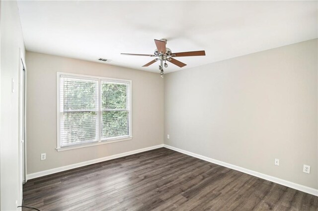 spare room featuring ceiling fan and dark wood-type flooring