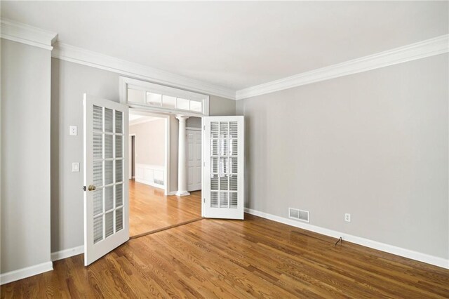 unfurnished room featuring ornamental molding and hardwood / wood-style flooring