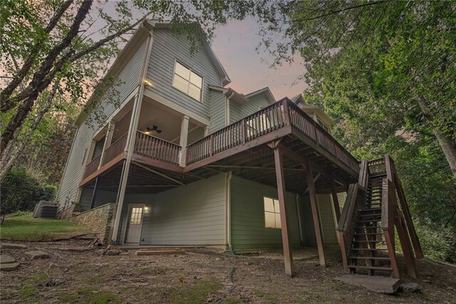 back house at dusk featuring a wooden deck