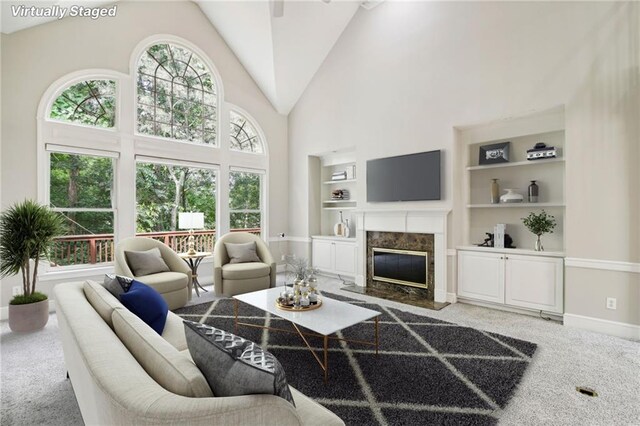 living room featuring a fireplace, high vaulted ceiling, carpet, and built in features