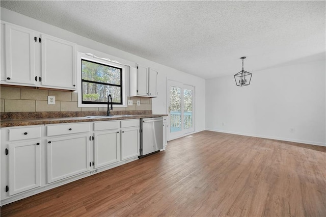 kitchen featuring a sink, dark countertops, light wood-style floors, and dishwasher