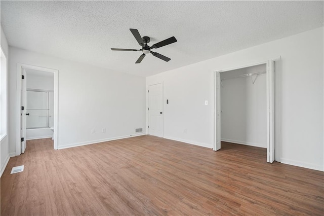 unfurnished bedroom featuring a textured ceiling, wood finished floors, and visible vents