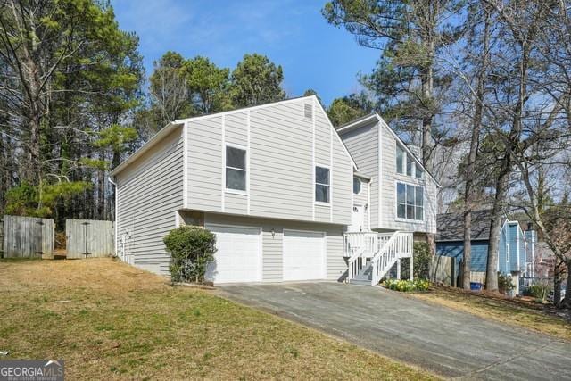 exterior space with a lawn, a garage, fence, and driveway