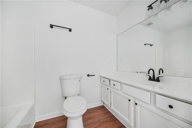 bathroom featuring vanity, visible vents, wood finished floors, toilet, and baseboards