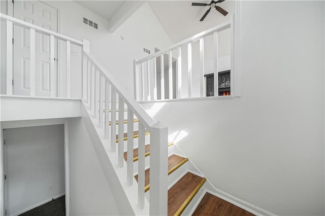 stairs featuring visible vents, baseboards, ceiling fan, and wood finished floors