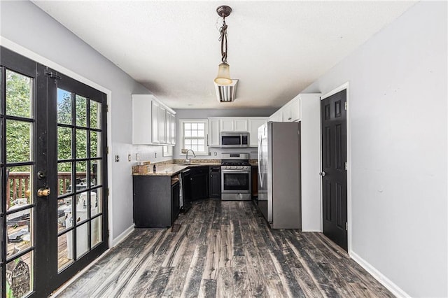 16 Bay Ct SW, Cartersville, GA 30120 - kitchen featuring appliances with stainless steel finishes, white cabinets, dark wood-type flooring, decorative light fixtures, and french doors