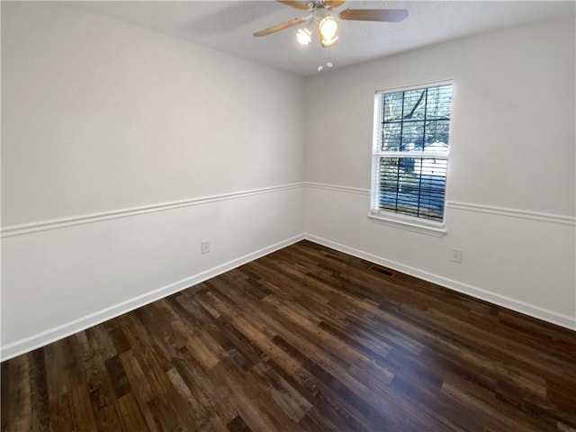 spare room featuring visible vents, baseboards, dark wood-type flooring, and ceiling fan