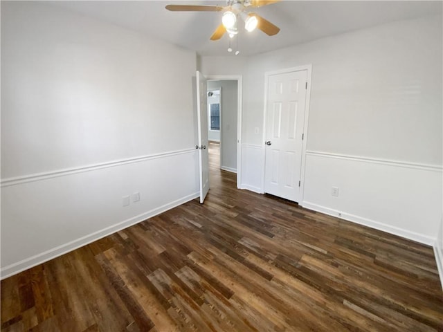 unfurnished bedroom featuring a ceiling fan, baseboards, and dark wood-style flooring