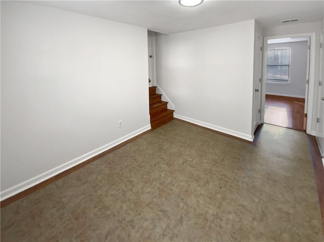 unfurnished room with tile patterned floors, visible vents, stairway, and baseboards