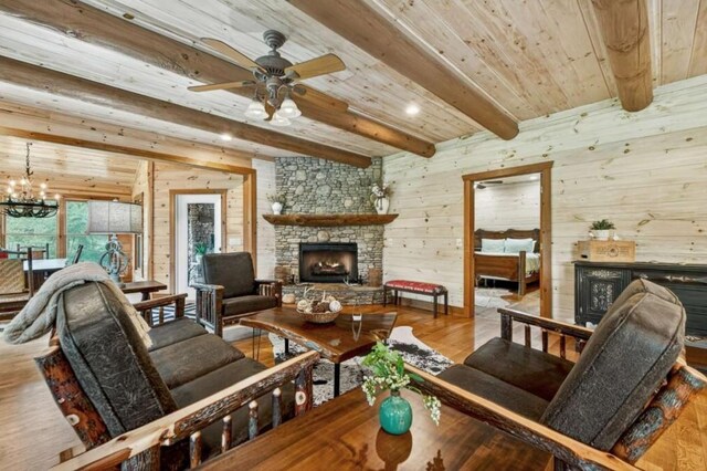 311 Bailey Farm Ln, Mineral Bluff, GA 30559 - living room featuring a fireplace, wooden walls, a wood ceiling with exposed beams, a ceiling fan, and wood finished floors