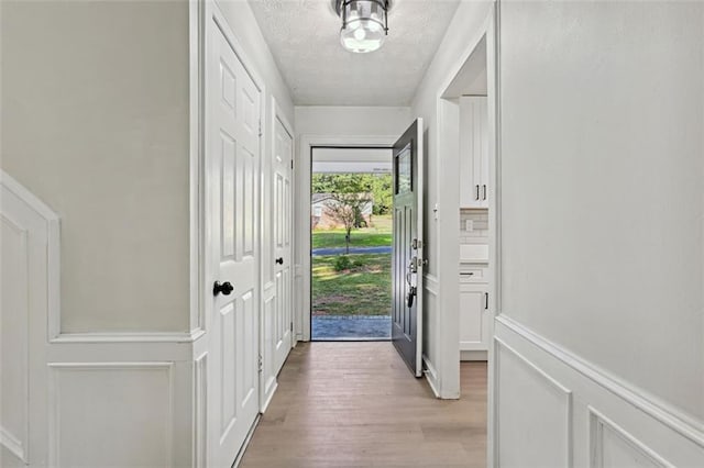 entryway featuring a textured ceiling and light hardwood / wood-style flooring