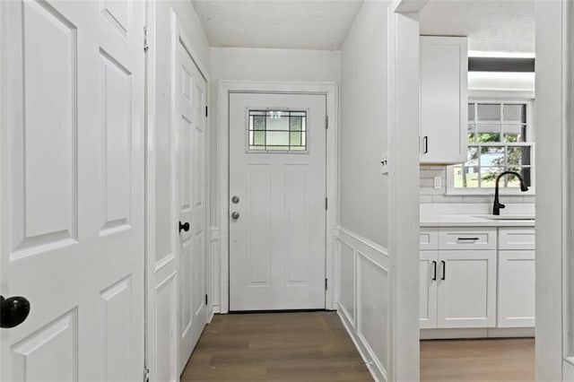 entryway featuring a textured ceiling, wood-type flooring, and sink