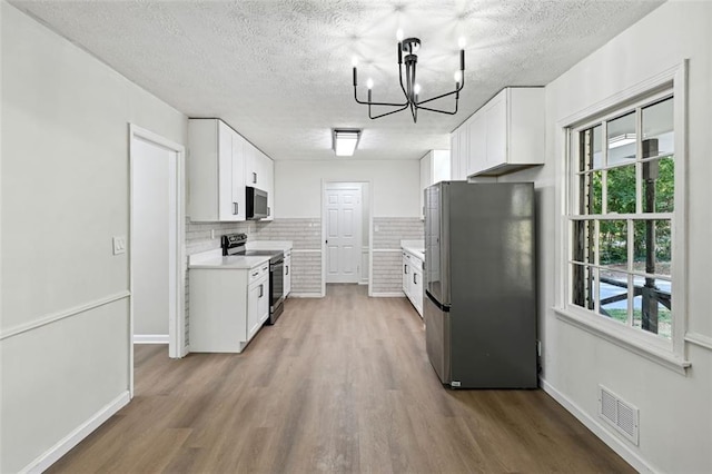 kitchen featuring white cabinets, appliances with stainless steel finishes, and a healthy amount of sunlight