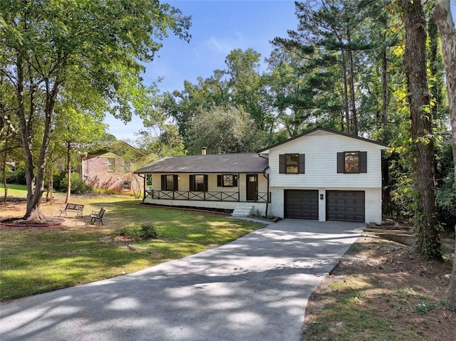 split level home with a front lawn, covered porch, and a garage