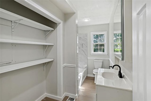 full bathroom featuring wood-type flooring, vanity, toilet, and  shower combination