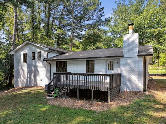 rear view of house with a deck and a yard