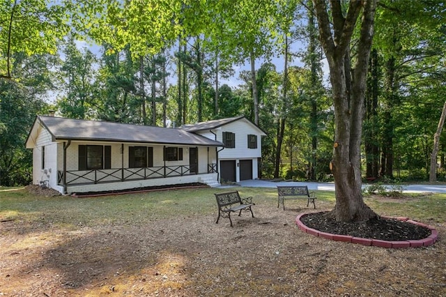 rear view of house featuring covered porch and a garage