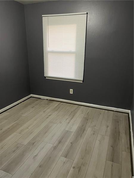 empty room with baseboards and wood finished floors