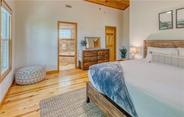 bedroom featuring multiple windows, wood finished floors, visible vents, and baseboards