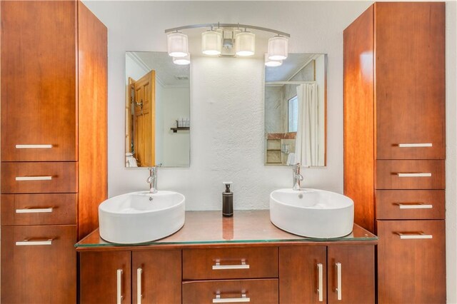 full bathroom featuring a sink and double vanity